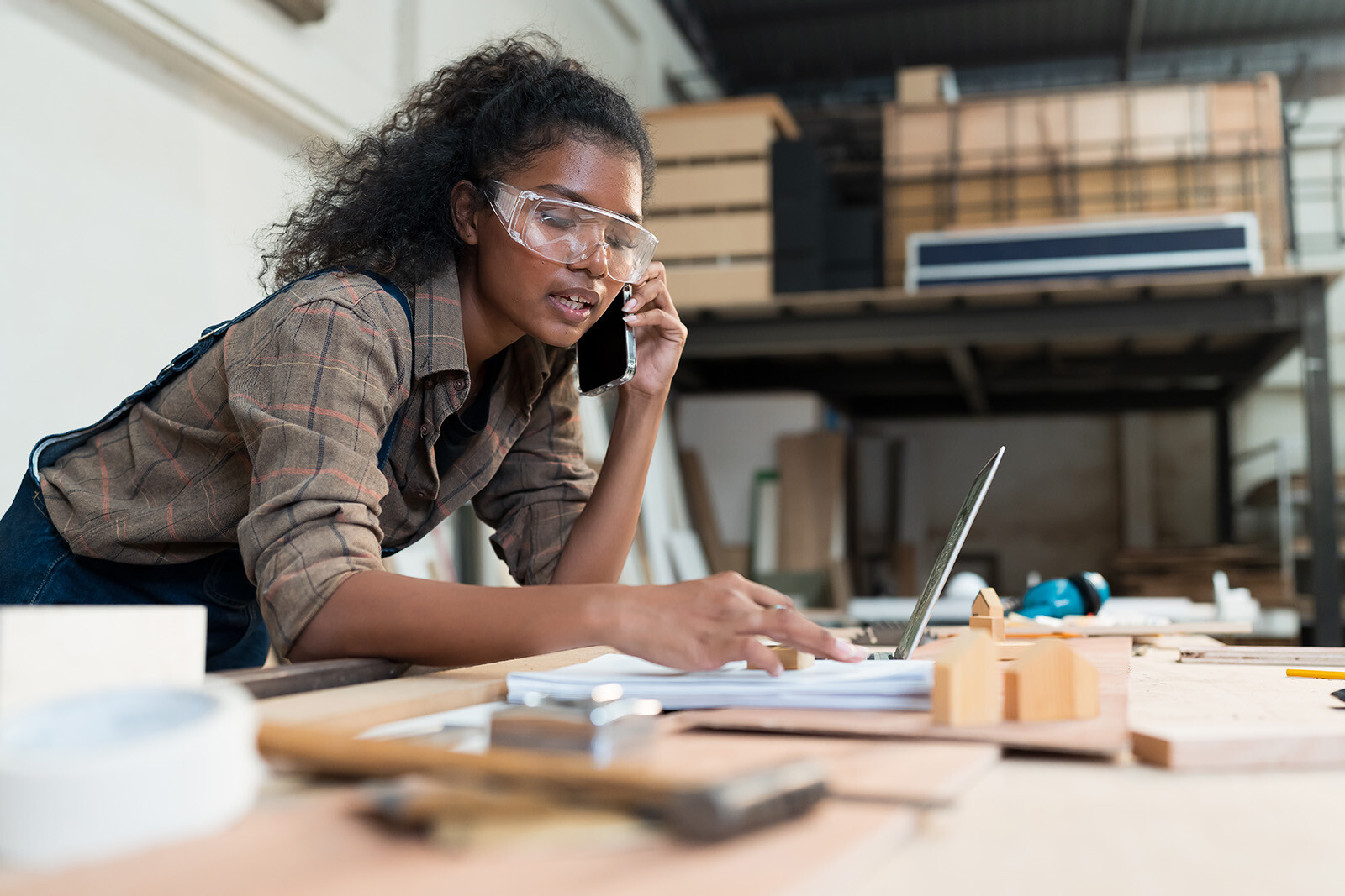 woman in her workshop on the phone placing an order