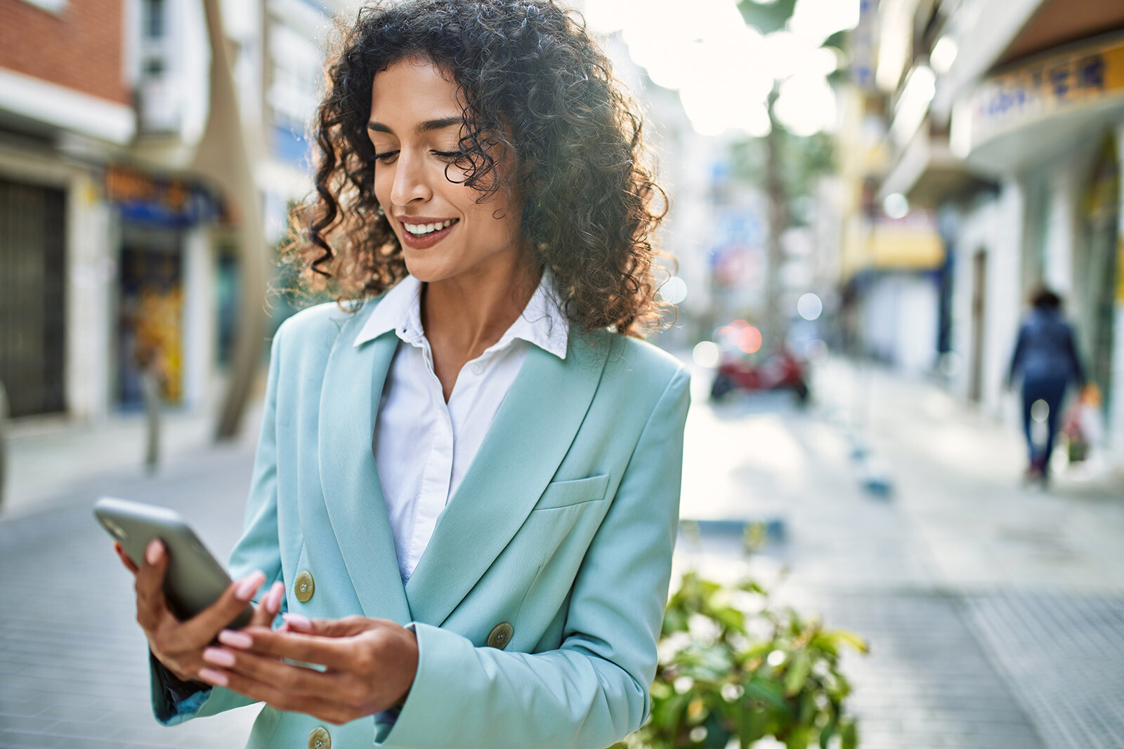 a bussinesswoman walking down the street on her phone